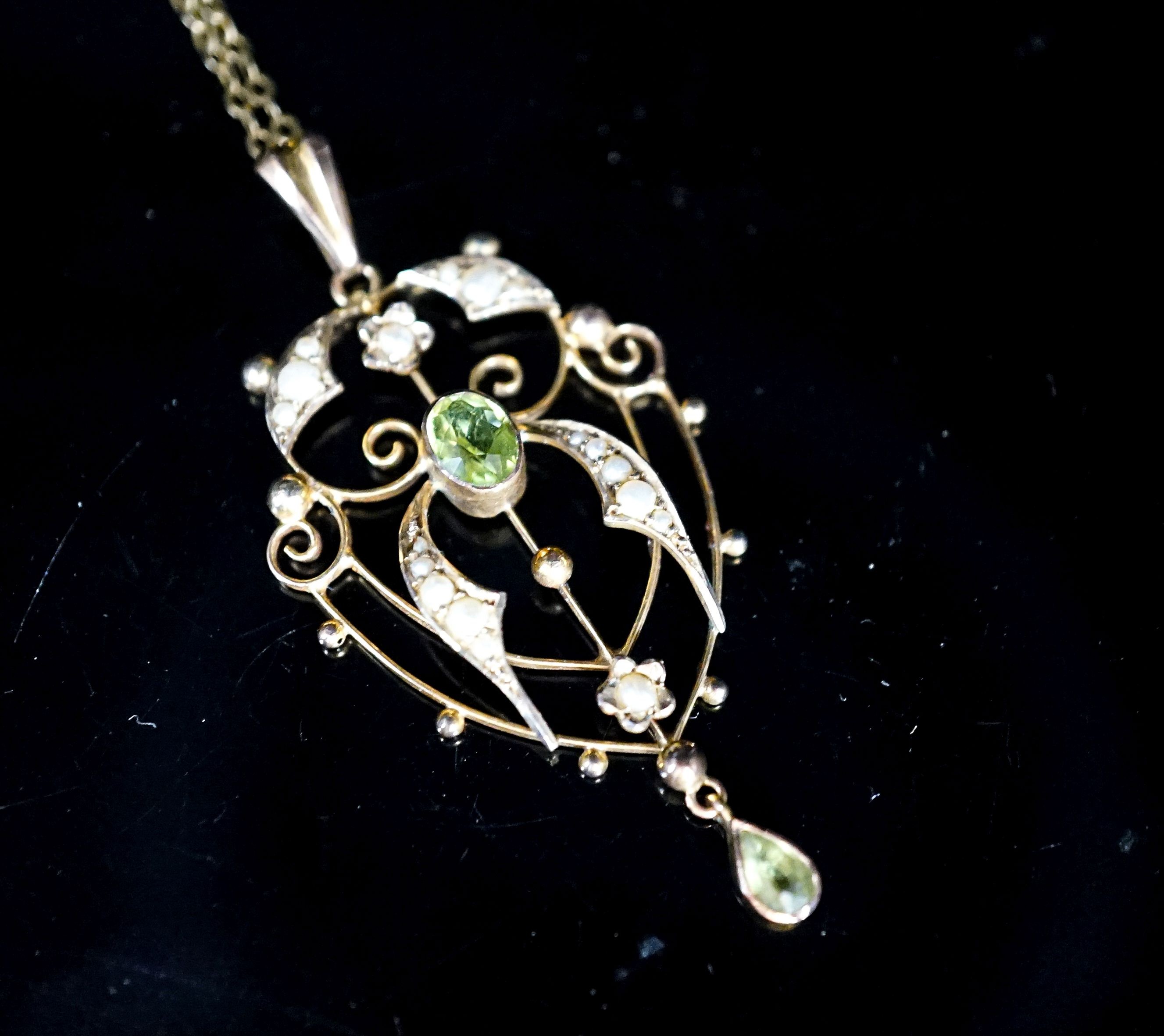 An Edwardian 9ct, peridot and seed pearl set drop pendant, 42mm, on a 9ct chain, 49cm